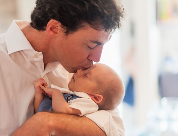 Father kissing baby son (0-1 months)