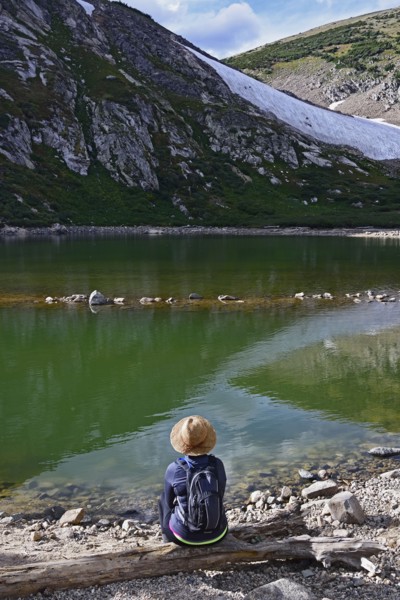 USA, Colorado, Idaho Springs, Hiker sitting by lake below Saint Mary's Glacier