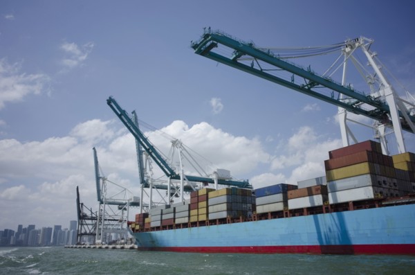 USA, Florida, Miami, Container ship with cranes and city skyline in background