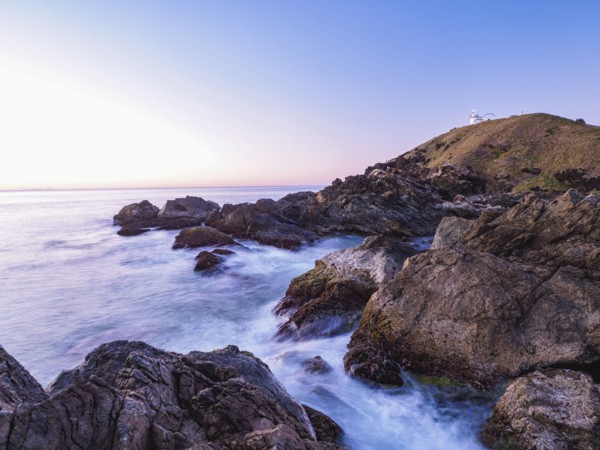 Australia, New South Wales, Port Macquarie, Lighthouse on rocky coat at sunrise