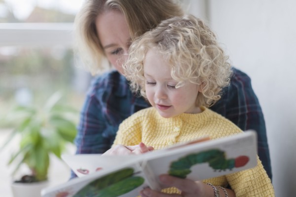 Mother reading book to daughter (4-5)