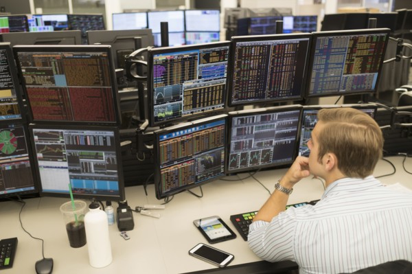 Young trader analyzing computer data.