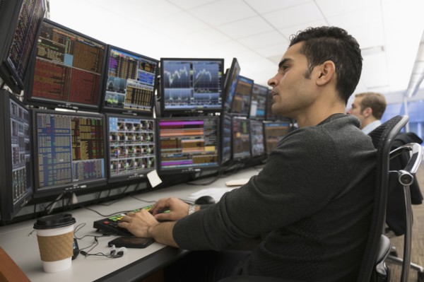 Young traders analyzing computer data.