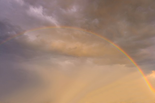 Rainbow against clouds in sunlight.