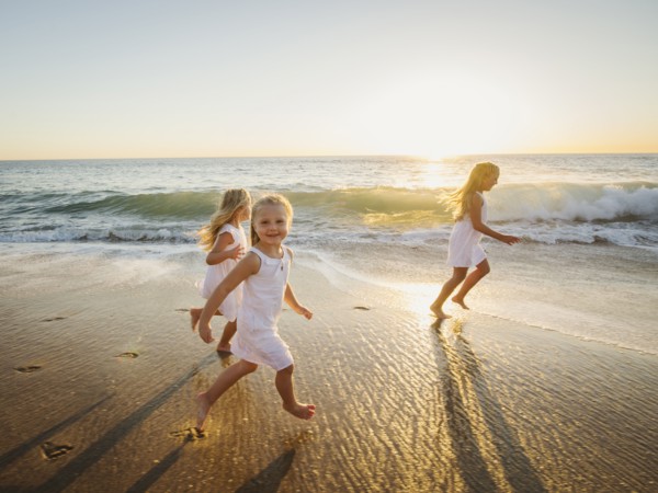 Girls (4-5, 6-7, 8-9) running on beach