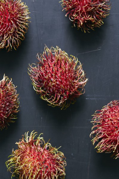 Rambutan (Nephelium lappaceum) fruits on grey surface