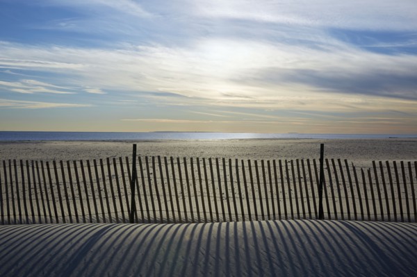 USA, New York, Lond Island, Fence by beach at sunset
