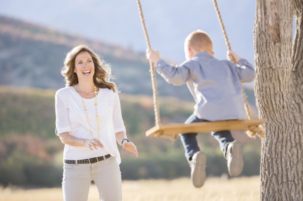 Mother with child (4-5) sitting on swing
