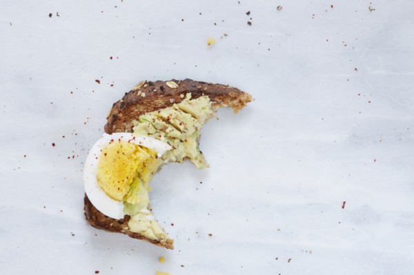 Missing bite of toasted bread with avocado and hard boiled egg