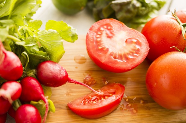 Tomato and radish on cutting board