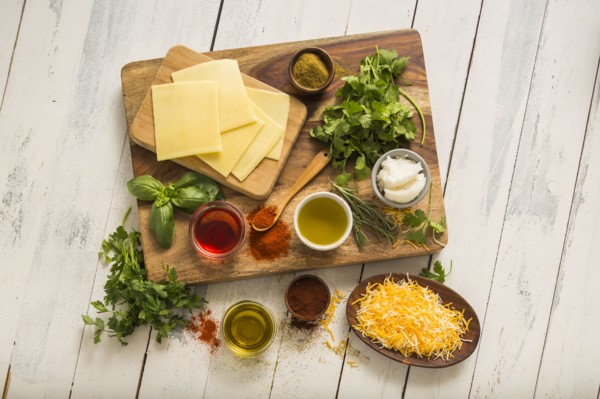 Cheese, herbs and spices on cutting board