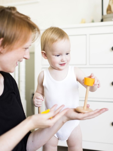 Mother playing with son (12-17 months) in nursery