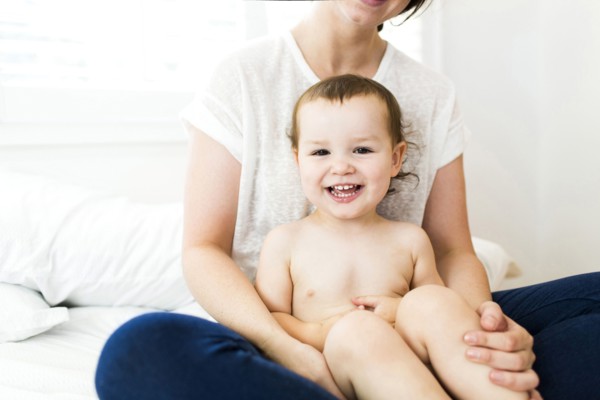 Mother sitting with son (4-5) on bed