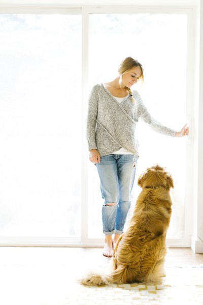 Young woman playing with golden retriever