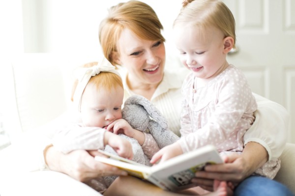Mother reading book to daughters ( 12-17 months )