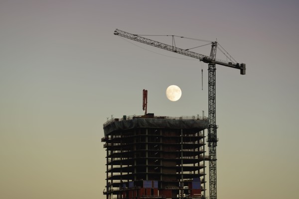 USA, Colorado, Denver, Full moon in background of skyscraper construction site at dusk