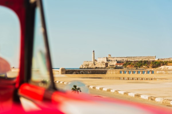 Cuba, Havana, Fort with lighthouse seen from convertible