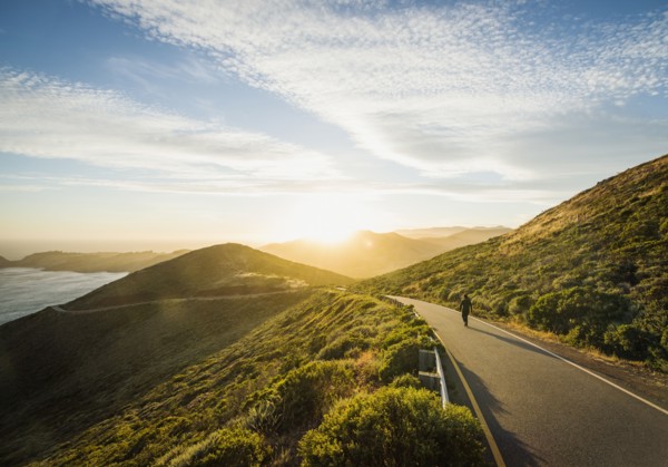 USA, California, San Francisco, California, Man walking on coastline road at sunset