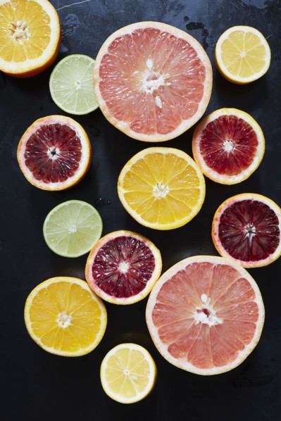 Halved fruits on black background