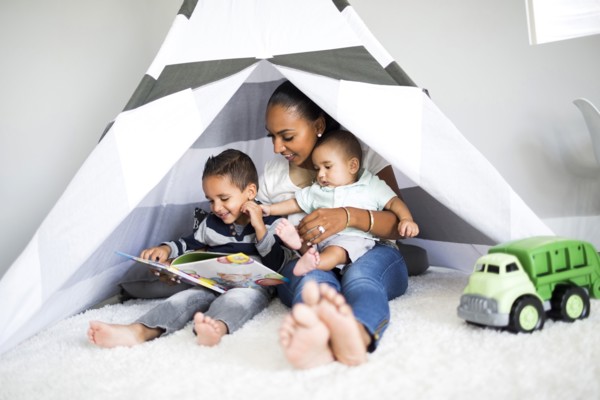 Mother playing with sons (2-5 months, 2-3) in toy tent