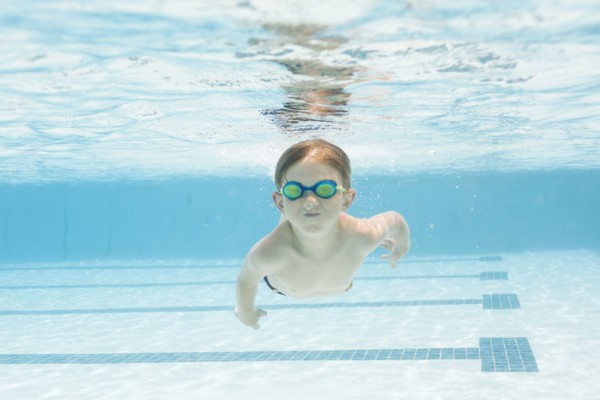 Boy (6-7) swimming in pool