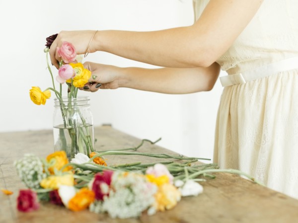 Woman putting flowers into jar