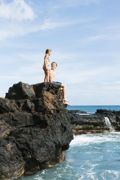 Man and girl (6-7) resting on cliff