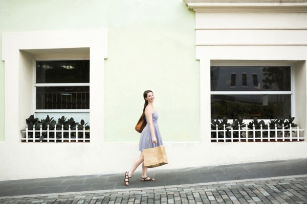 Puerto Rico, San Juan, Woman with shopping bag walking city streets