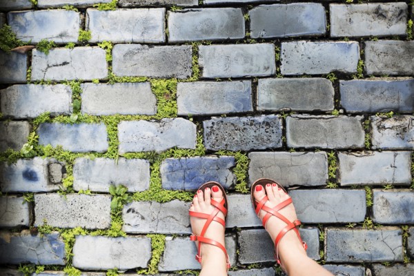 Woman in sandals standing on street