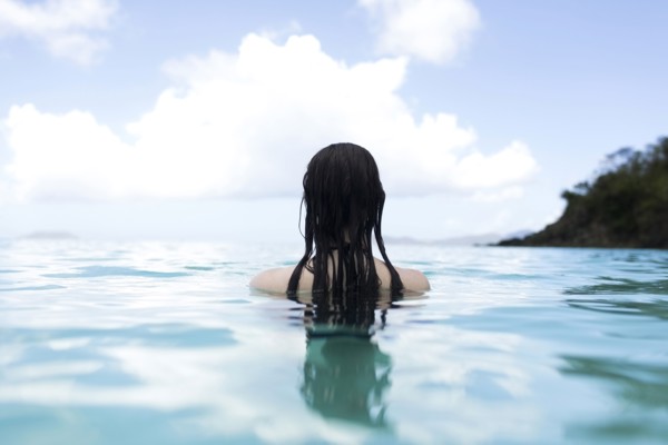 USA, Virgin Islands, Saint Thomas, Woman with long hair standing in bay