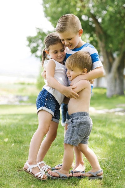 Siblings (2-3, 4-5, 6-7) embracing in park