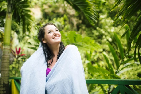 Caribbean Islands, Saint Lucia, Woman with wet hair wrapped in towel with lush foliage in background