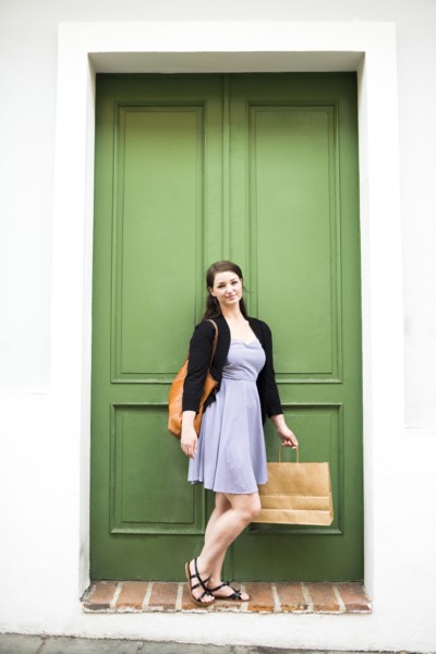 Puerto Rico, San Juan, Woman with shopping bag standing in front of green door