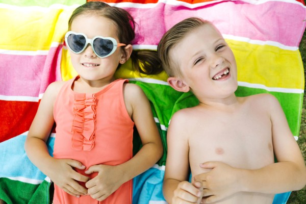 Portrait of girl (4-5) and boy (6-7) lying on towel