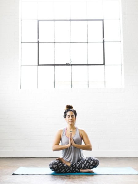 Woman meditating on exercise mat