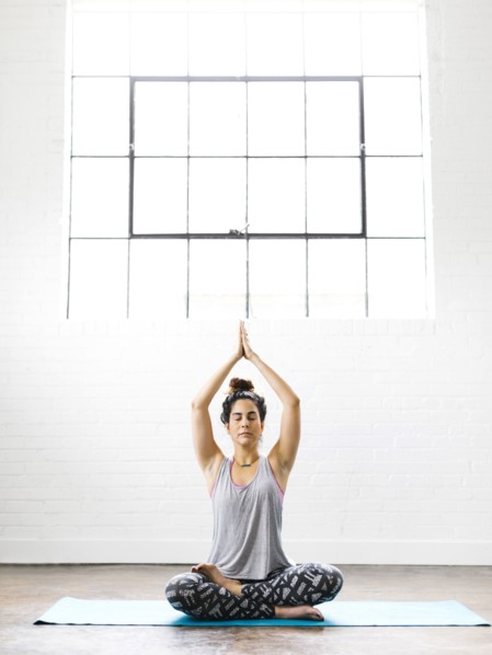 Woman meditating on exercise mat