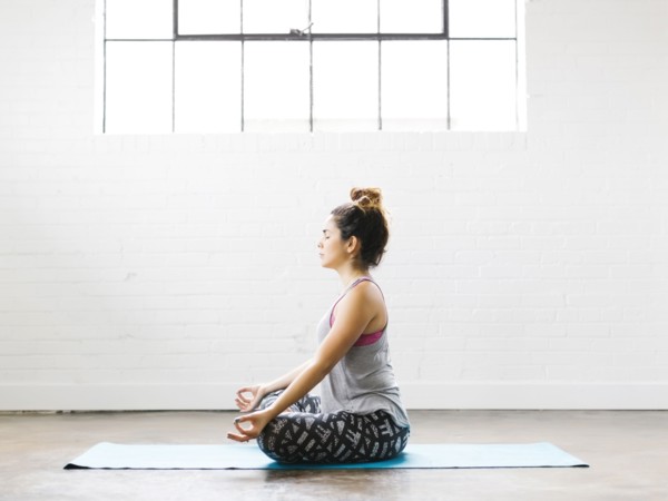 Woman meditating on exercise mat