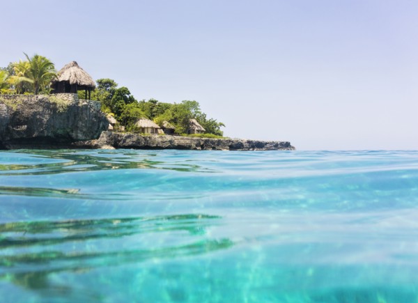 Jamaica, Negril, Traditional huts on rocky coastline
