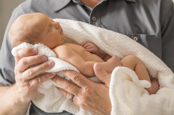 Father embracing newborn son (0-1 month)