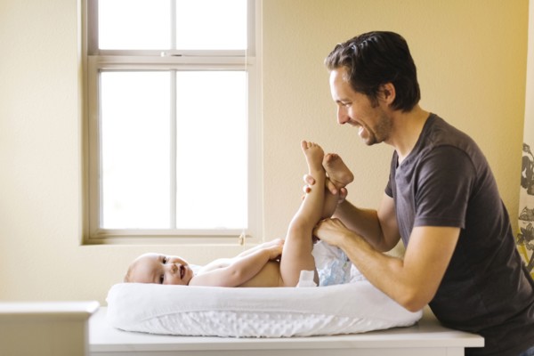 Father changing son's (12-17 months) diaper