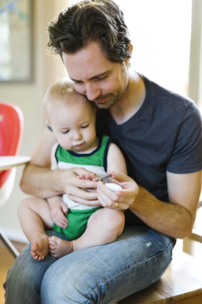 Father clipping nails to son (12-17 months)