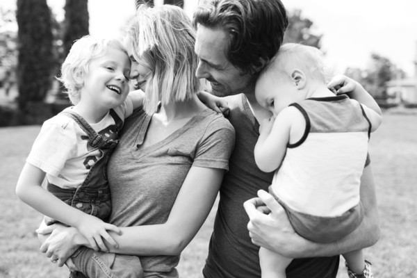 Portrait of parents with sons (12-17 months, 4-5) in park