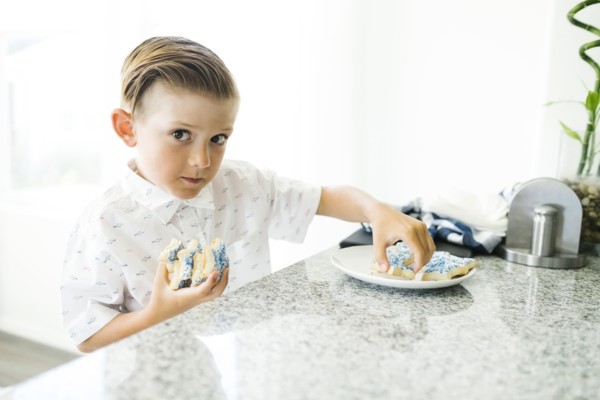 Boy (8-9) stealing cookies