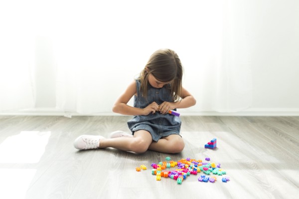 Girl (6-7) playing with plastic blocks