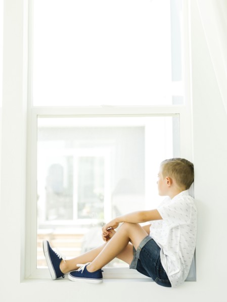Boy (6-7) looking through window