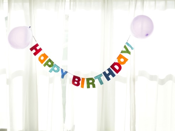 Birthday garland hanging in front of net curtain