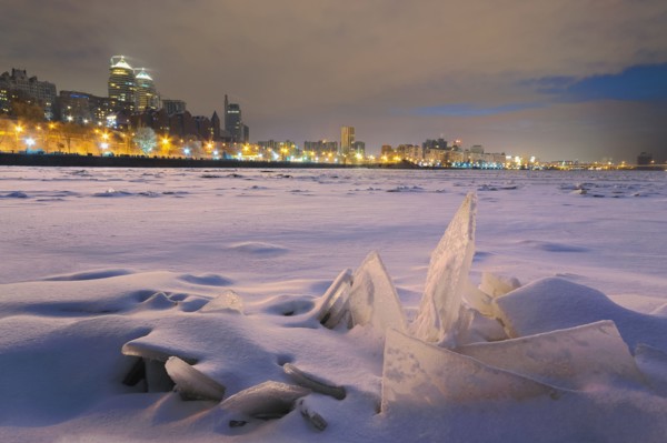 Ukraine, Dnepropetrovsk region, Dnepropetrovsk city, Frozen river with distant city skyline at night