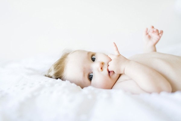 Portrait of baby girl (6-11 Months) with finger in mouth