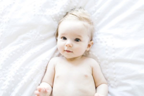 Portrait of baby girl (6-11 Months) smiling, directly above