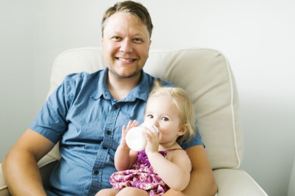 Father feeding baby girl (12-17 months) in living room